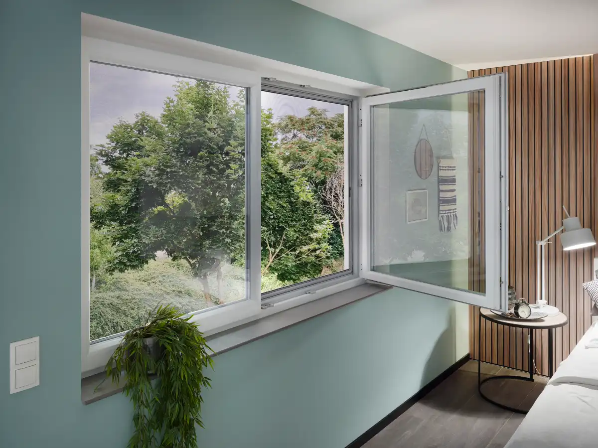 Offenes Fenster mit Insektenschutz im Schlafzimmer Offenes Fenster mit Blick auf grüne Bäume und modernes Schlafzimmer